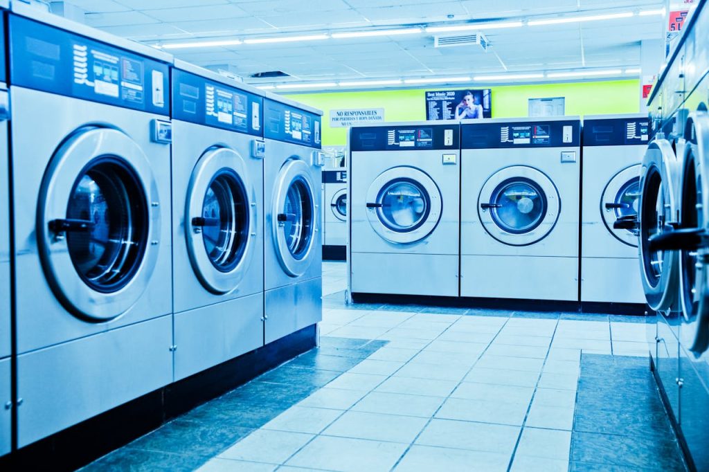 photo-of-front-load-washing-machines-4700410 Bright and contemporary laundromat with rows of washing machines.